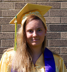 Female graduate poses with a diploma