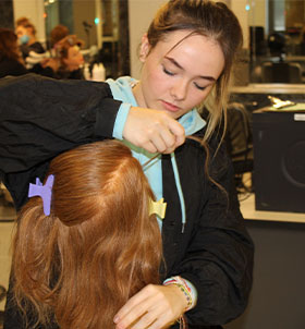 Student styling hair on mannequin